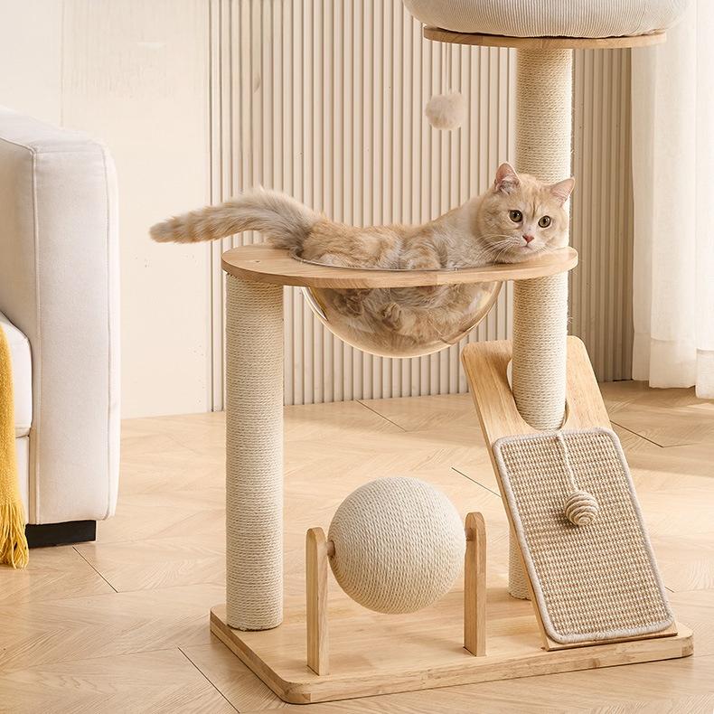 Cat lounging on a wooden cat tree with a hammock, scratching posts, and a ball.