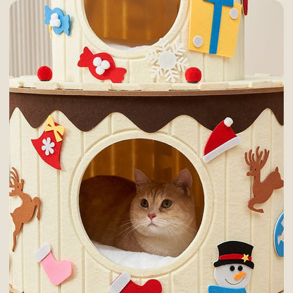 A cream-colored cat tree with a round window opening showing a fluffy orange cat inside. The birthday cake cat tree is decorated with festive Christmas felt cutouts, including a reindeer, stocking, snowman, candy, and snowflake, with a small yellow gift box hanging at the top.