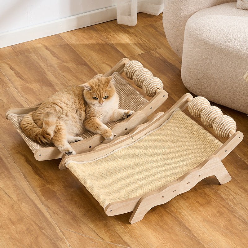 Two wooden cat hammock beds with woven straw-like floors are shown on a wooden floor, with an orange cat resting on one bed. A cream upholstered chair is partially visible in the background.