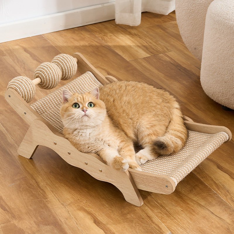 An orange tabby cat lies on a wooden cat lounge bed with a woven beige cushion and sisal rope-wrapped headrest, placed on a wooden floor in a home setting.