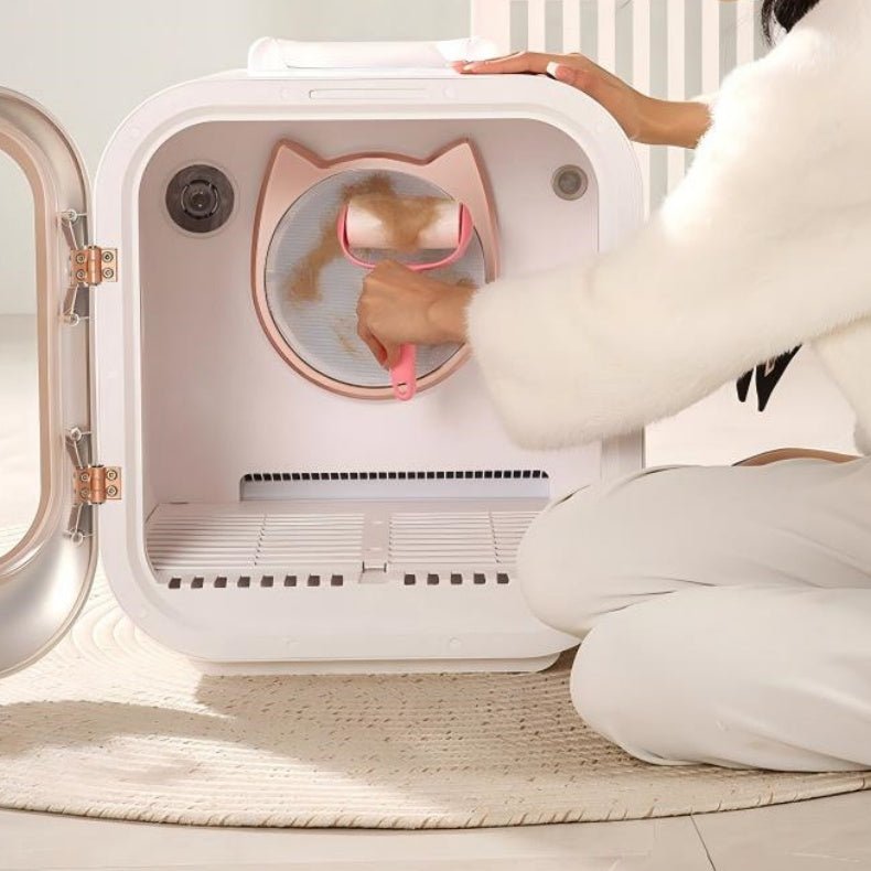Person interacting with a smart pet dryer box on a light wooden floor.