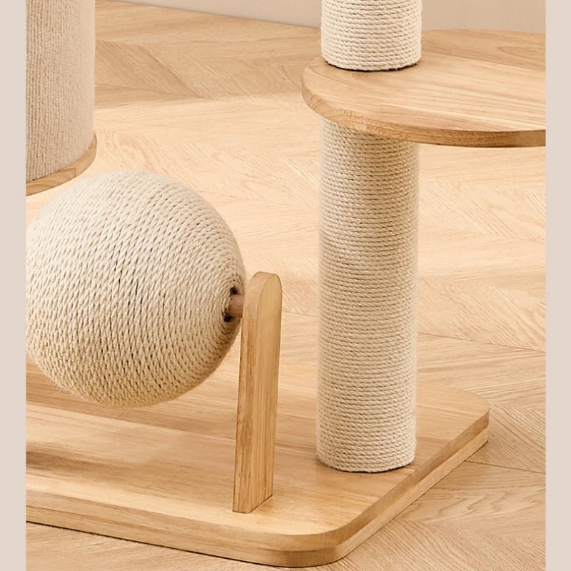 A wooden cat tree with sisal-wrapped scratching posts and a ball toy, shown on a light wood herringbone floor.