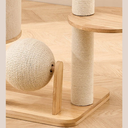 A wooden cat tree with sisal-wrapped scratching posts and a ball toy, shown on a light wood herringbone floor.