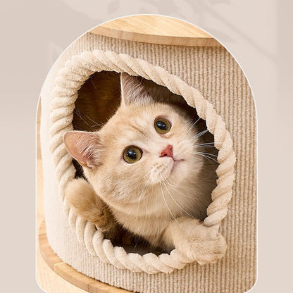 A cute cat peeking out of a round, rope-trimmed cat tree hide made of beige corduroy fabric, set against a light beige background.
