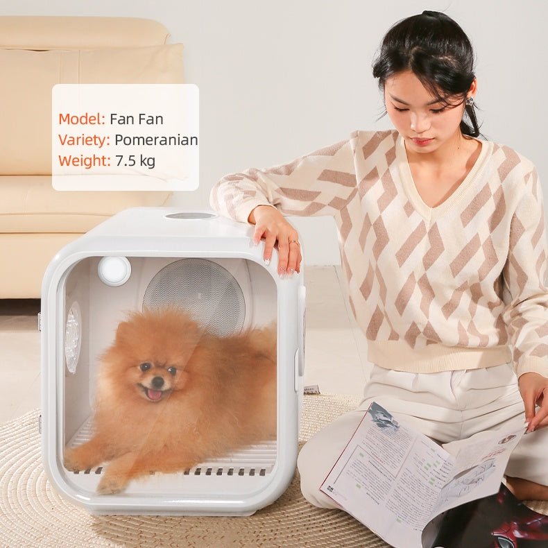 A woman with a Pomeranian dog in a pet hair drying cabinet on a couch